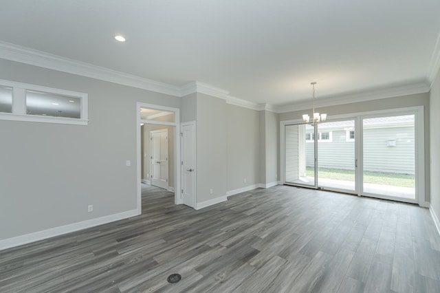 spare room with a chandelier, dark wood-type flooring, and crown molding