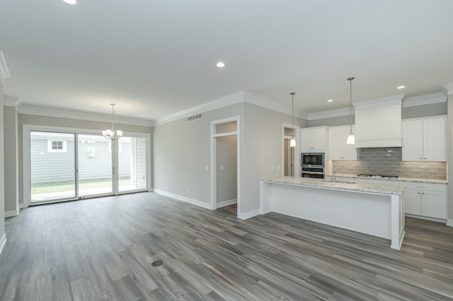 kitchen with premium range hood, ornamental molding, wood-type flooring, white cabinetry, and light stone countertops