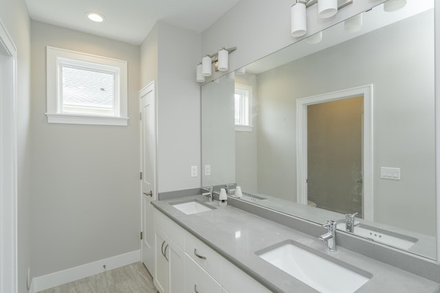 bathroom with a healthy amount of sunlight, hardwood / wood-style flooring, and vanity