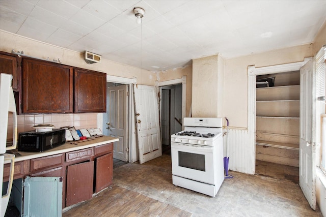 kitchen with white gas stove and backsplash