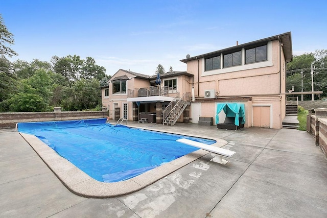 view of pool featuring a patio, a deck, and a diving board