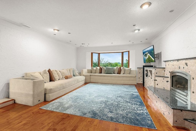 living room with light wood-type flooring and a textured ceiling