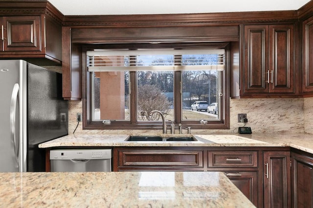 kitchen featuring appliances with stainless steel finishes, backsplash, dark brown cabinetry, and sink