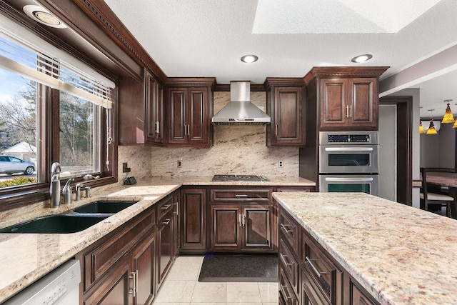 kitchen featuring light tile patterned flooring, sink, wall chimney exhaust hood, decorative backsplash, and appliances with stainless steel finishes