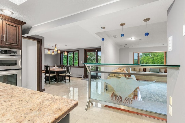 rec room featuring light tile patterned floors, a baseboard heating unit, and a wealth of natural light