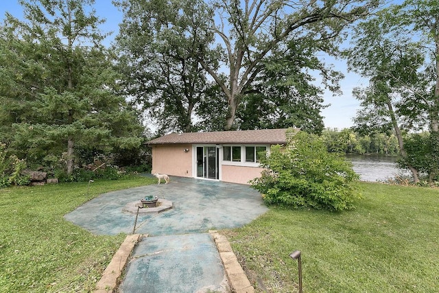 view of front of property with a patio, a water view, and a front lawn