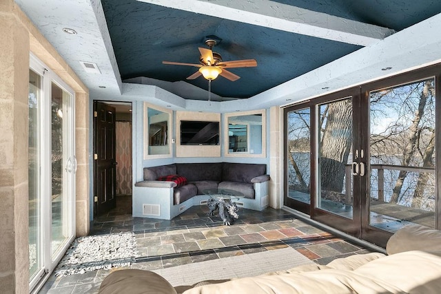 sunroom / solarium featuring a tray ceiling and ceiling fan