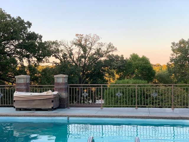 view of pool at dusk