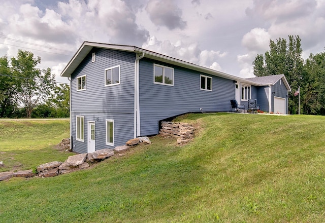 rear view of property with a garage and a yard