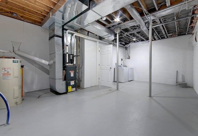 basement featuring separate washer and dryer, water heater, and heating unit