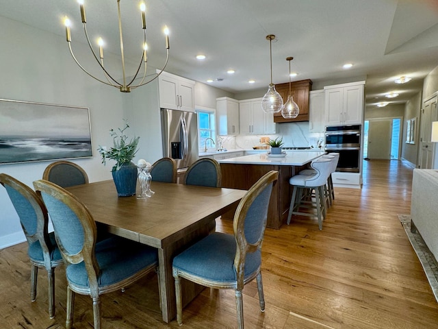 dining space featuring light wood-style flooring and recessed lighting