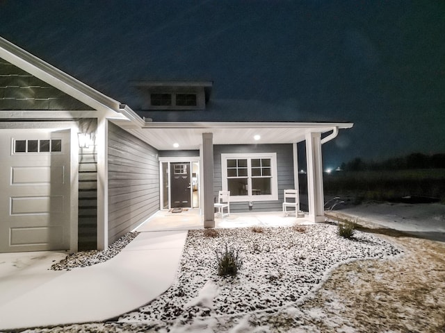 doorway to property with a porch and an attached garage