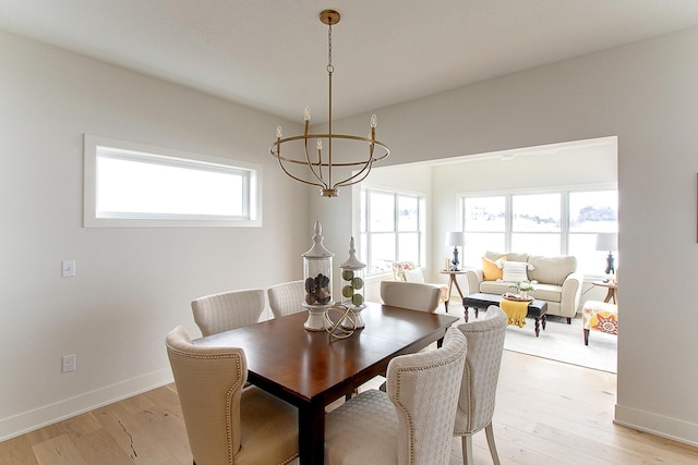 dining room featuring baseboards, plenty of natural light, and light wood-style floors