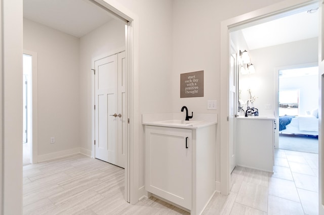 corridor with a sink and baseboards