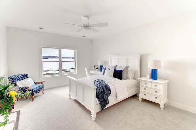 bedroom with baseboards, light colored carpet, and a ceiling fan