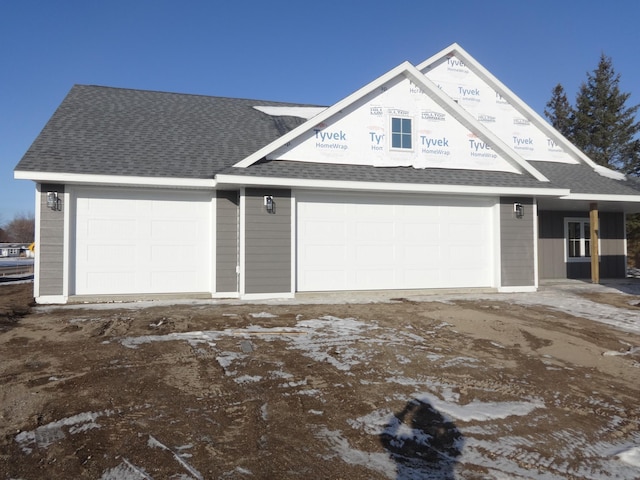 view of front facade featuring a shingled roof and a garage