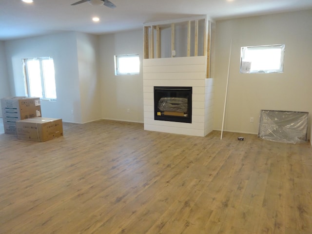 unfurnished living room featuring plenty of natural light, light hardwood / wood-style floors, and ceiling fan