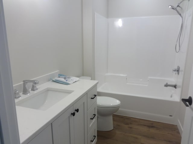 full bathroom with vanity, washtub / shower combination, toilet, and wood finished floors