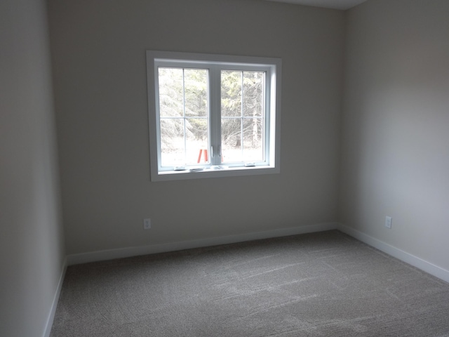 unfurnished room featuring carpet flooring and baseboards