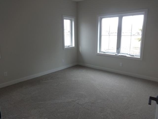 empty room with baseboards and carpet