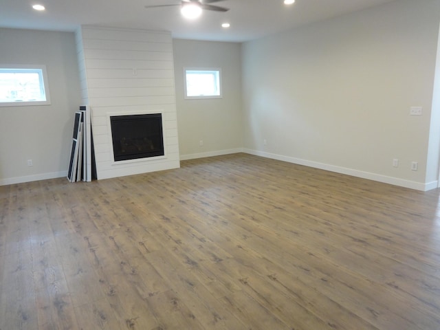981 White Spruce Ln NW, Alexandria, MN 56308 - unfurnished living room featuring a ceiling fan, wood-type flooring, a large fireplace, and recessed lighting