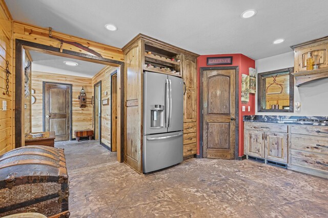 kitchen featuring wood walls and stainless steel refrigerator with ice dispenser