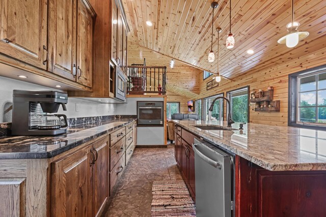 kitchen with a center island with sink, sink, decorative light fixtures, and stainless steel appliances