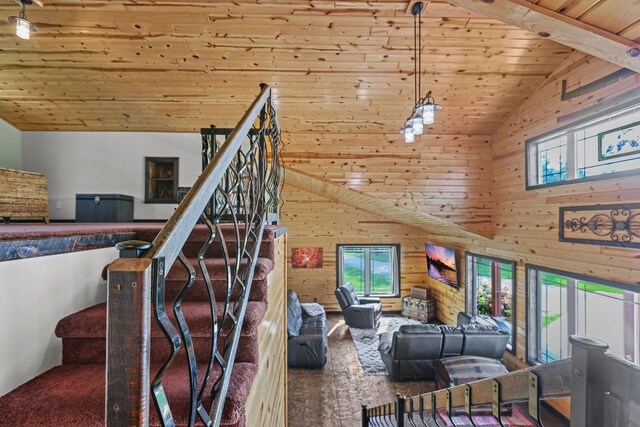 staircase featuring wooden walls, hardwood / wood-style flooring, high vaulted ceiling, and wooden ceiling