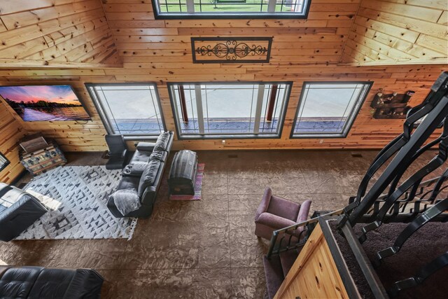 interior space with high vaulted ceiling, wood walls, and multiple windows