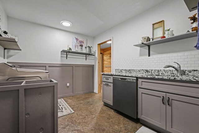 kitchen with sink, dishwasher, gray cabinetry, and tasteful backsplash