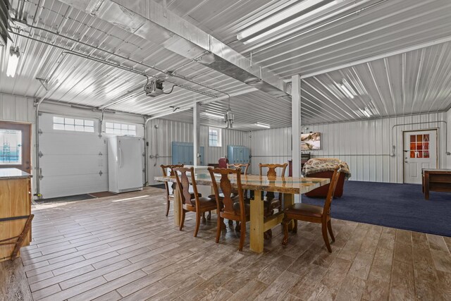 dining room featuring hardwood / wood-style floors and wooden walls