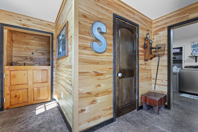 hall with washer / clothes dryer and wooden walls