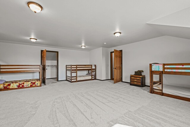 bedroom with lofted ceiling and light carpet