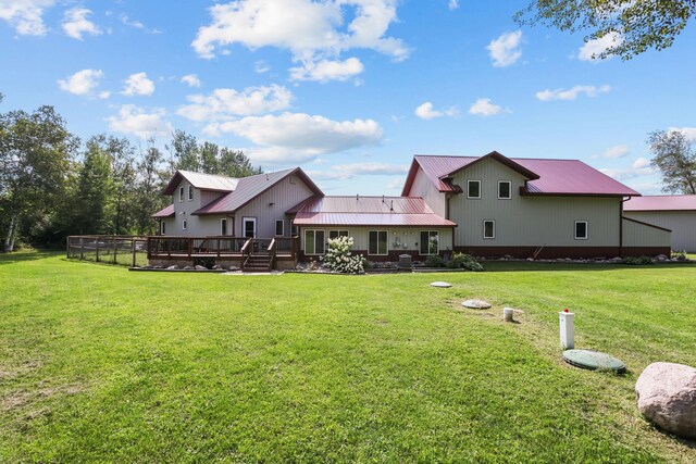 back of property with a deck and a lawn