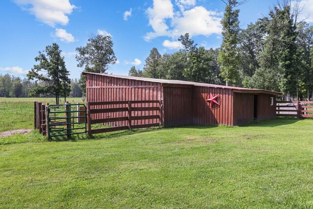 view of outdoor structure featuring a lawn and a rural view