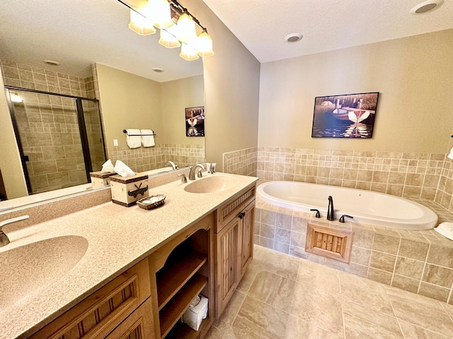 bathroom with vanity, a textured ceiling, plus walk in shower, and tile patterned flooring