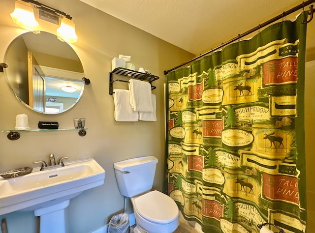 bathroom with toilet, a shower with curtain, and a sink