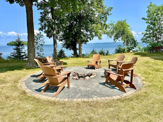 surrounding community featuring a water view, a yard, and a fire pit