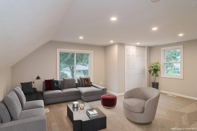 carpeted living room featuring vaulted ceiling