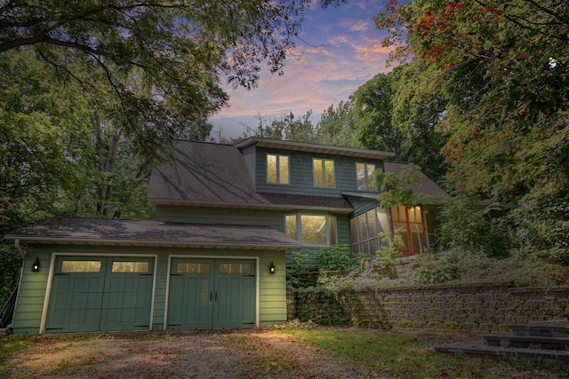 view of front of property featuring a garage and dirt driveway