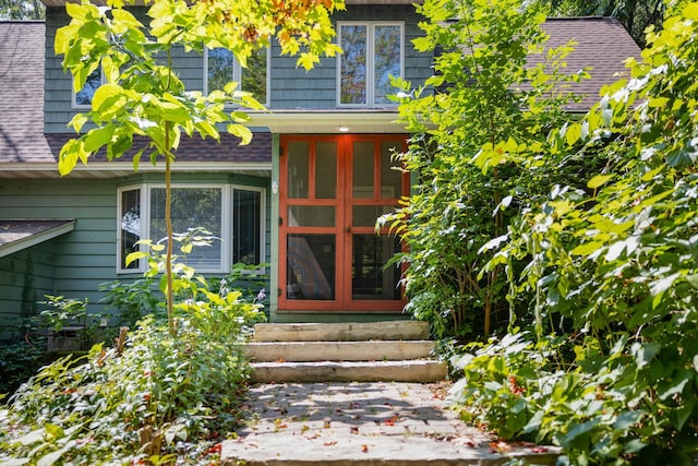 entrance to property featuring a shingled roof