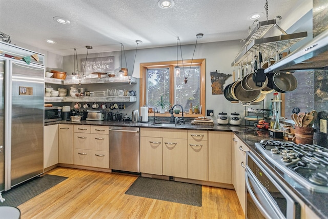 kitchen featuring pendant lighting, open shelves, stainless steel appliances, dark countertops, and light brown cabinetry