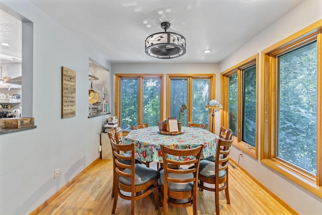 dining space with baseboards and light wood finished floors