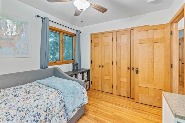 bedroom featuring a ceiling fan, a closet, and light wood finished floors