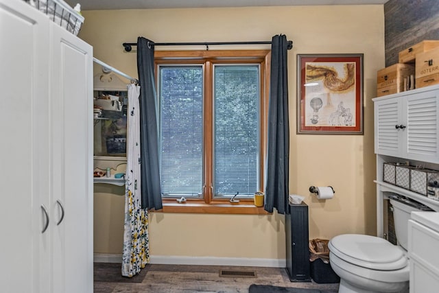 full bathroom with toilet, wood finished floors, visible vents, and baseboards