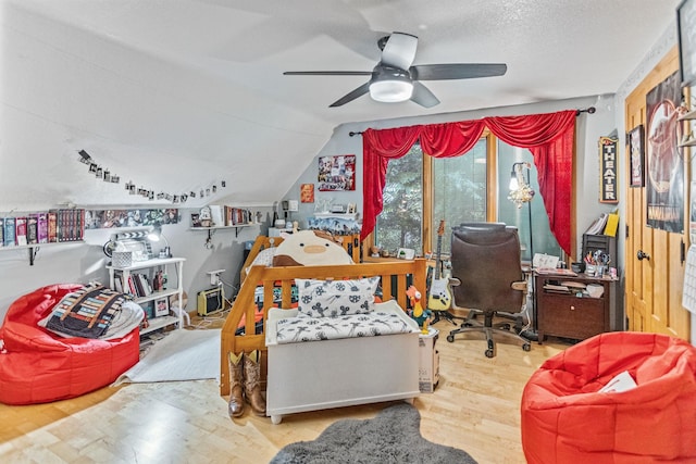 interior space featuring lofted ceiling, a textured ceiling, wood finished floors, and a ceiling fan