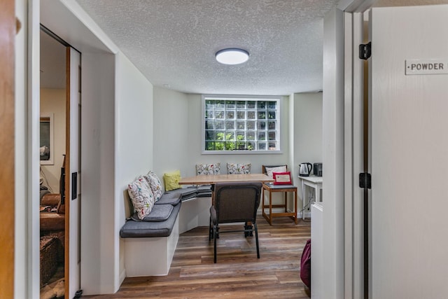 home office with a textured ceiling and dark wood-type flooring