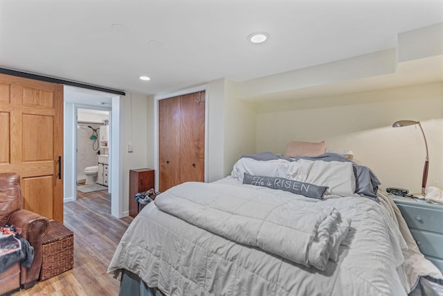 bedroom featuring recessed lighting, baseboards, a closet, light wood finished floors, and ensuite bath