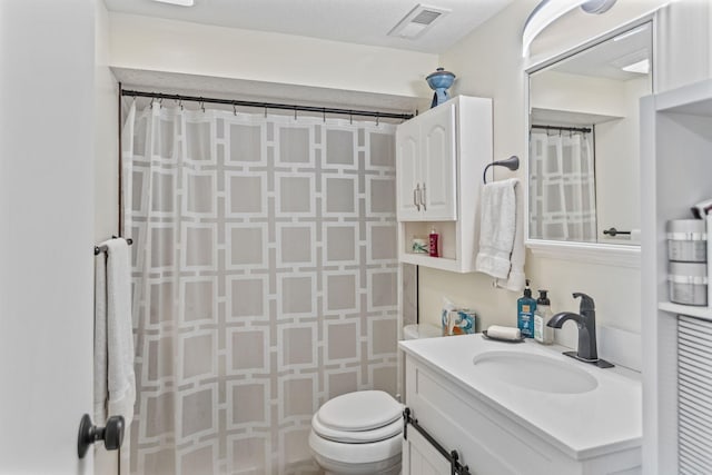 bathroom featuring toilet, a shower with curtain, visible vents, and vanity