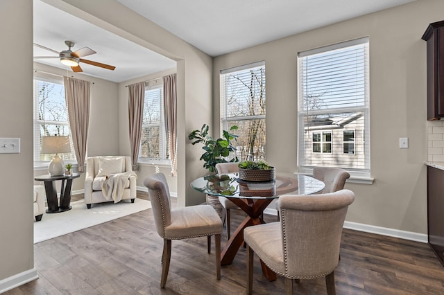 dining area featuring dark wood-type flooring, ceiling fan, and baseboards